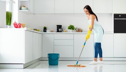 Kobieta myje podłoge mopem ze spryskiwaczem